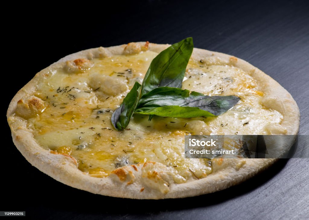 fresh italian pizza on black background Four Objects Stock Photo