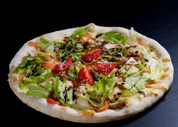 istock fresh italian pizza on black background 1129903226
