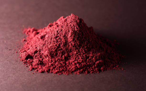 istock handful of red powder on gray background 1129903486