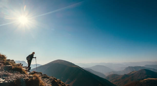 istock Backpacker hiker on the mountain hill in contrast sun light 1129909204