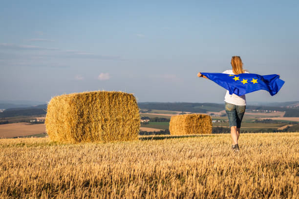 istock Woman with EU flag in fields. 1129916844