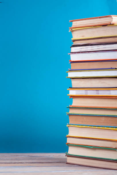 istock Stack of colorful real books on blue background, partial view. Back to school. Copy Space. Education background. 1129917310