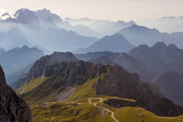 Mountain silhouettes in the Julian Alps, Slovenia, at sunset, in a warm late Summer day, as seen comming down from Mangart peak Mountain silhouettes in the Julian Alps, Slovenia, at sunset, in a warm late Summer day, as seen comming down from Mangart peak julian alps stock pictures, royalty-free photos & images