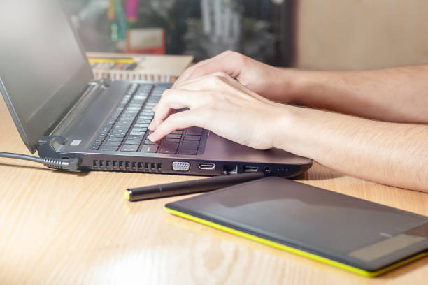 istock Closeup image of hand using and touching on laptop on wooden table 1129918192