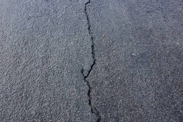istock gray asphalt stone texture on a road with a crack 1129925173