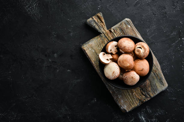 istock Mushrooms in a plate. Champignons on the old background. Top view. Free copy space. 1129926114