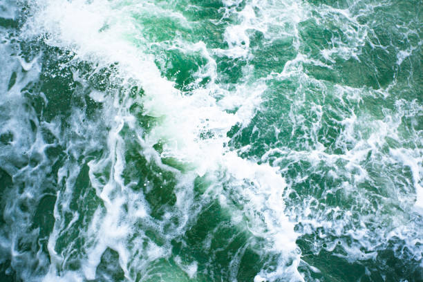 istock surface of turquoise ocean water with white foam, background, texture 1129929054