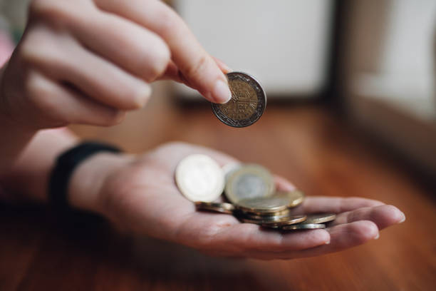 istock Woman counting coins in her hand 1129932726