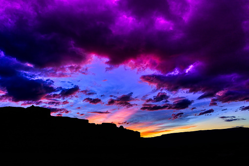 Wide Angle Desert Landscape Sunset - Colorful sky at sunet with clouds moving overhead and lined with pink.