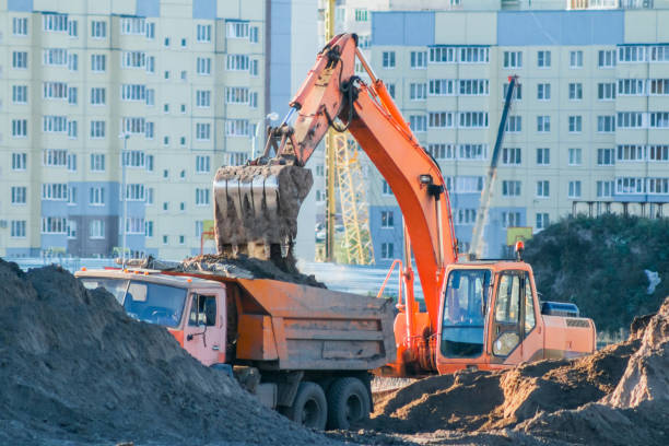 istock Excavator loads the earth into a dump truck. 1129938340