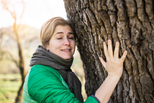 istock Woman hugging tree outdoors 1129967186