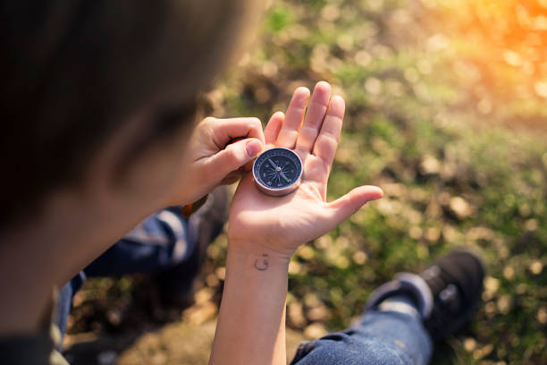 Young girl holding an old compass in hand natural background Using wallpaper or background travel or navigator image stock photo
