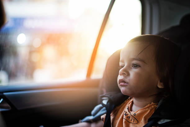 Baby boy into him car seat in sunny day stock photo