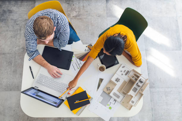 Architects at work Overhead view of two architects working on a project in the office slovenia photos stock pictures, royalty-free photos & images