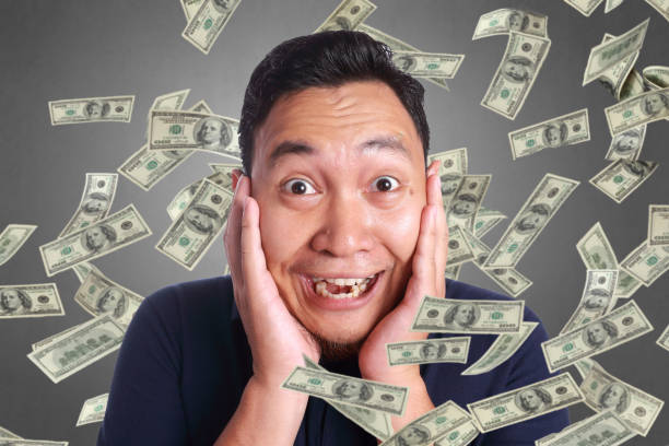 istock Young Man Under Rain of Money 1129971007