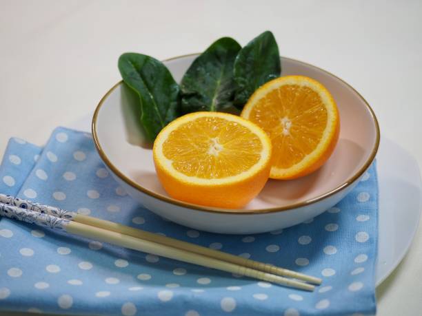 Orange and spinach in a ceramic bowl Shot in studio 깨끗한 stock pictures, royalty-free photos & images