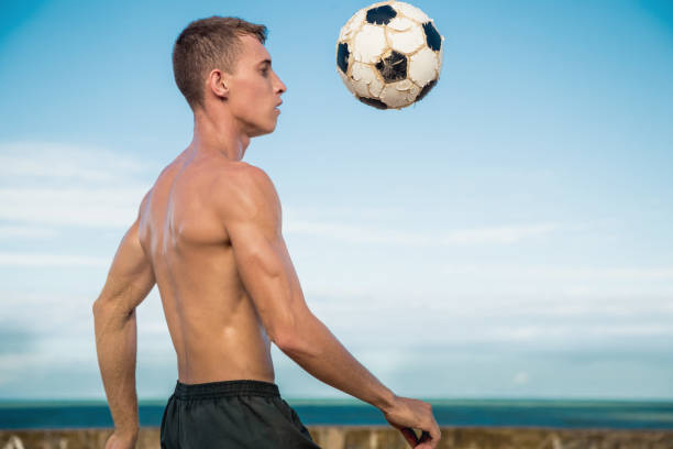 istock Player playing soccer on the beach 1129976243