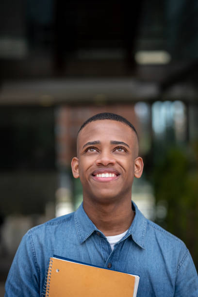 istock Handsome black young university student looking up very cheerfully 1129999653