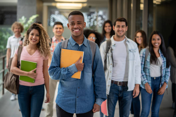 istock Diverse group of young students at a college building facing camera smiling 1129999675