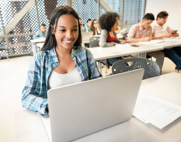istock Portrait of beautiful black student using her laptop during class looking very happy 1129999716