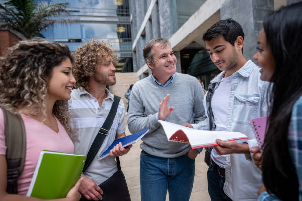 istock Group of college students talking to friendly male teacher 1129999751
