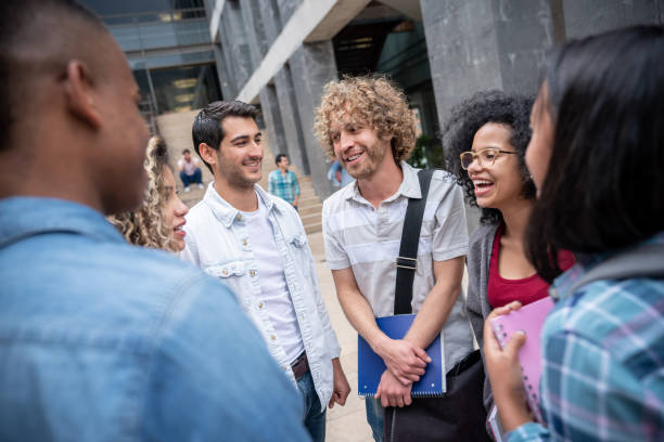 istock Cheerful friends standing in a circle talking and laughing 1129999766