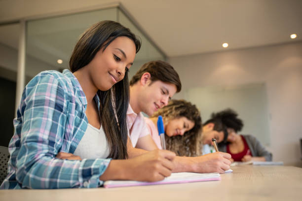 istock Beautiful young black female student writing on her notebook focused but smiling 1129999783