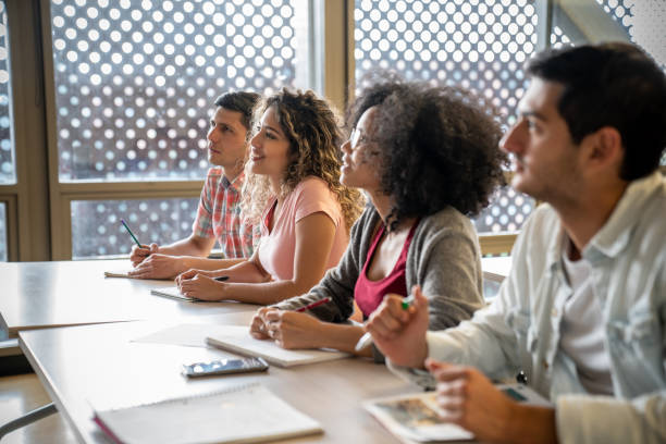 istock Young latin american diverse students paying attention during class at the university 1129999792