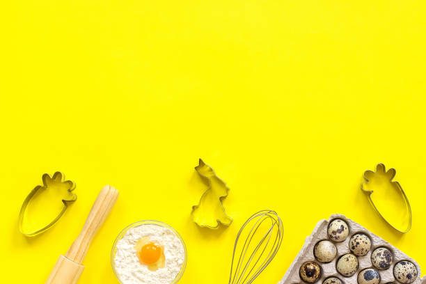 istock Baking Easter composition. Rolling pin, whisk for whipping, cookie cutters, quail eggs flour on yellow background. Top view Copy space Creative happy easter concept Template for text or your design 1130022989