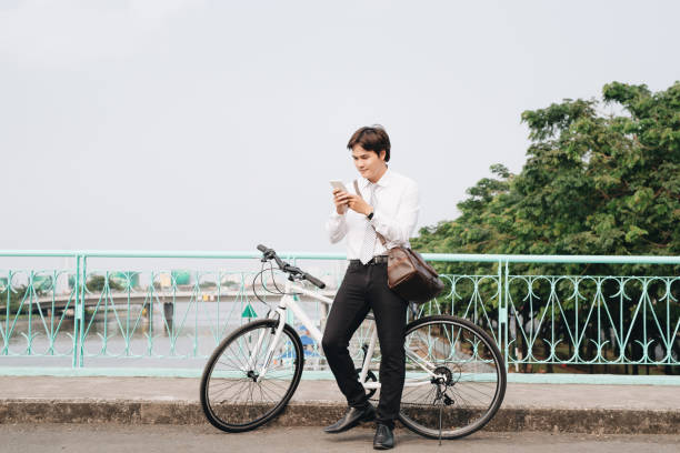 istock Young handsome guy on a bicycle looking at mobile phone. 1130024492