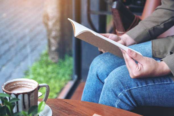 istock woman opening a book to read with notebooks 1130029820