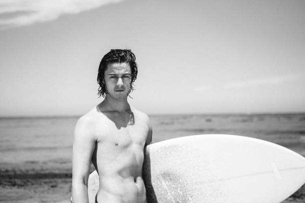 istock Sensuous shirtless male with surfboard at beach 1130040922