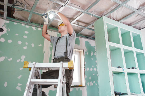 istock Room repair. Interior finish. young builder makes a plasterboard ceiling, standing on a stepladder 1130042862