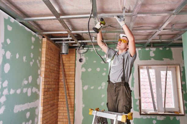 istock Room repair. Interior finish. young builder makes a plasterboard ceiling, standing on a stepladder 1130044033