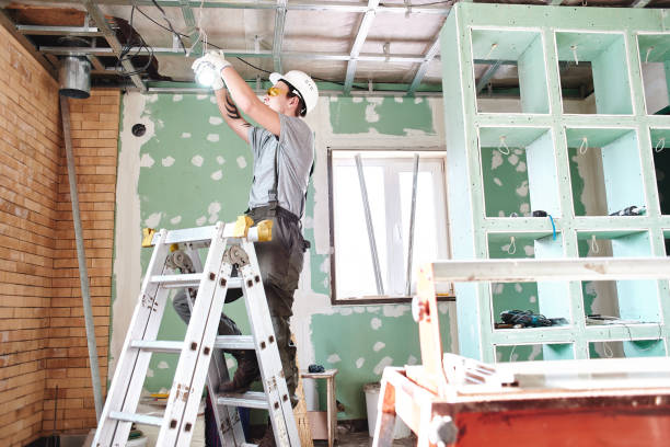 istock Room repair. Interior finish. young builder makes a plasterboard ceiling, standing on a stepladder 1130044808
