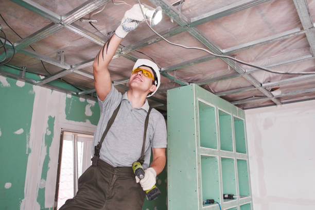 istock Room repair. Interior finish. young builder makes a plasterboard ceiling, standing on a stepladder 1130044923