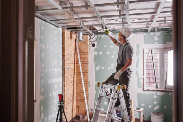istock Room repair. Interior finish. young builder makes a plasterboard ceiling, standing on a stepladder 1130044999