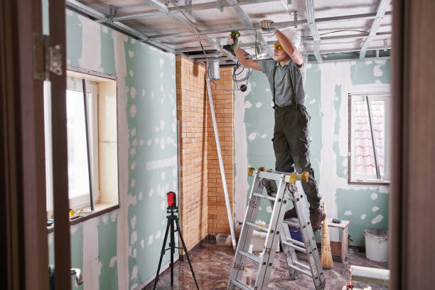istock Room repair. Interior finish. young builder makes a plasterboard ceiling, standing on a stepladder 1130045724