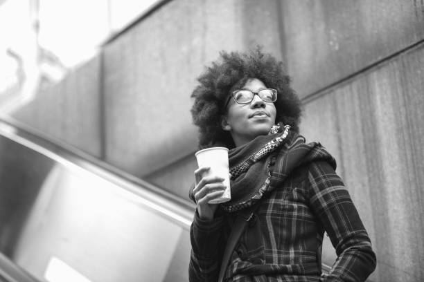 istock Beautiful young woman drinking coffee on escalator 1130045730