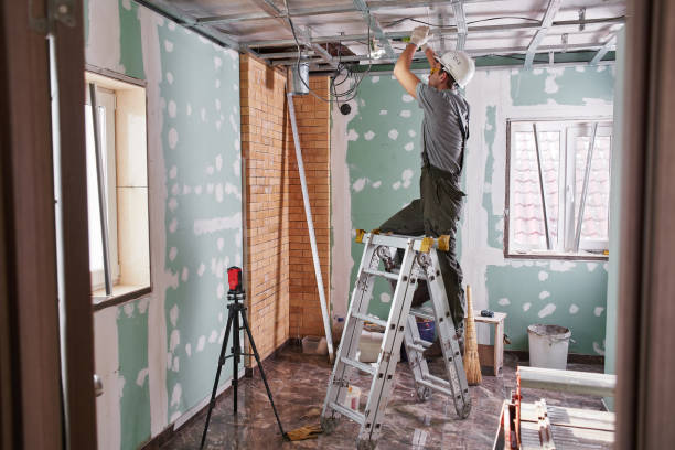 istock Room repair. Interior finish. young builder makes a plasterboard ceiling, standing on a stepladder 1130045969