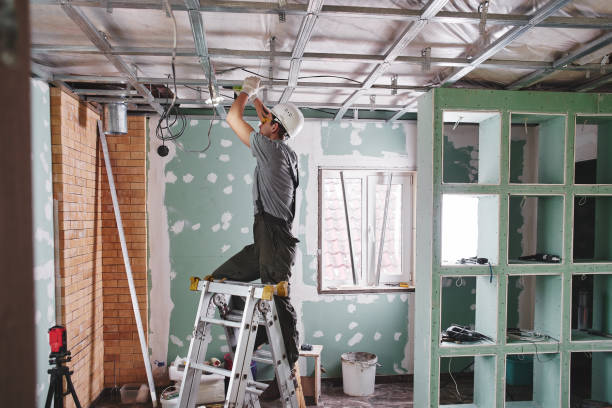 istock Room repair. Interior finish. young builder makes a plasterboard ceiling, standing on a stepladder 1130046987