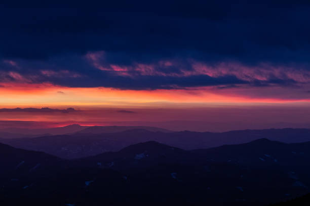 istock Beautifully colored sky at dusk, with mountains layers 1130048067