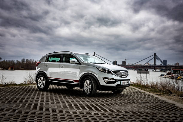 suv kia sportage 2.0 crdi awd or 4x4, white color, parked on the banks of the river sava, on the stormy weather with gloomy clouds. - europe bridge editorial eastern europe imagens e fotografias de stock