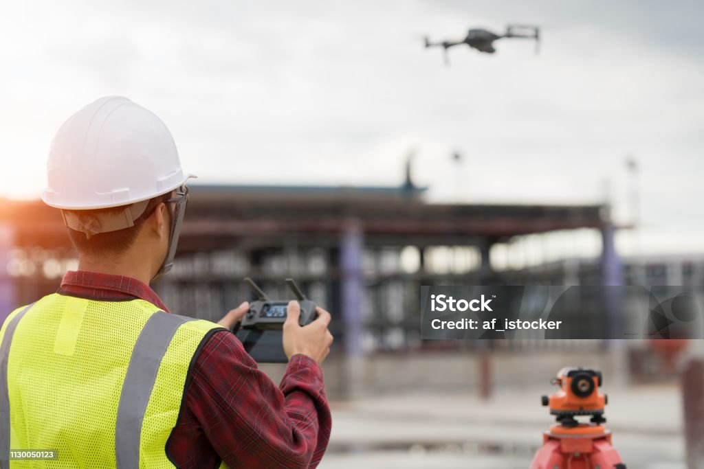 Ingenieur landmeter werken met drone op bouwplaats - Royalty-free Radiografisch bestuurd vliegtuig Stockfoto