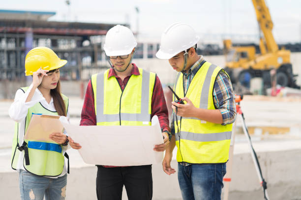 istock Civil engineers at construction site and a land surveyor using an  theodolite 1130050182