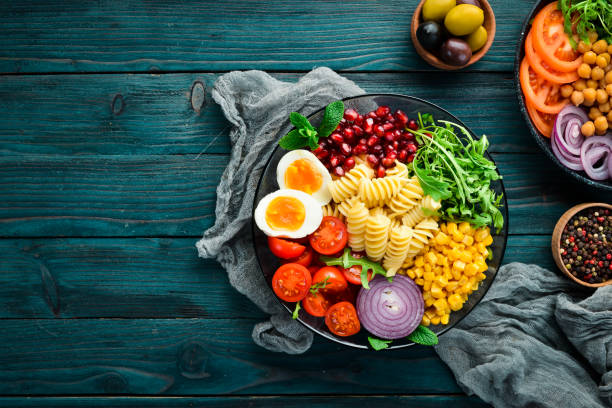 istock Pasta with corn, egg, tomato, arugula, in a bowl. Bowl Buddha Top view. free space for your text. 1130050797