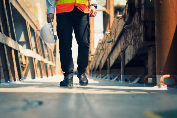 istock Foreman using walkie-talkie and safety boots to work in Cargo ship 1130057122