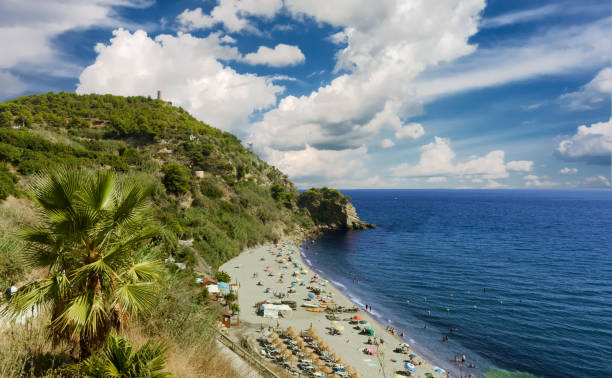 la playa de maro (spiaggia di maro) con un grande cielo con nuvole. località turistica in costa del sol, andalusia, spagna. - nerja foto e immagini stock