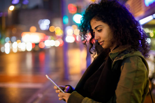 junge frau zu fuß auf der straße in der nacht - catch light stock-fotos und bilder