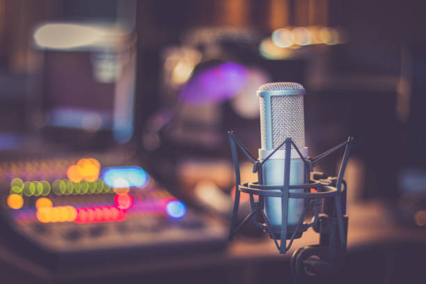 Microphone in a professional recording or radio studio, equipment in the blurry background stock photo